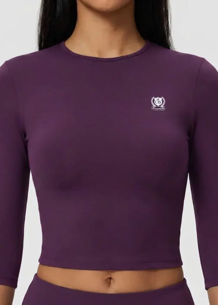 Purple long-sleeve top with a small logo on a plain background